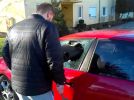 A man breaks his own car’s window after locking keys